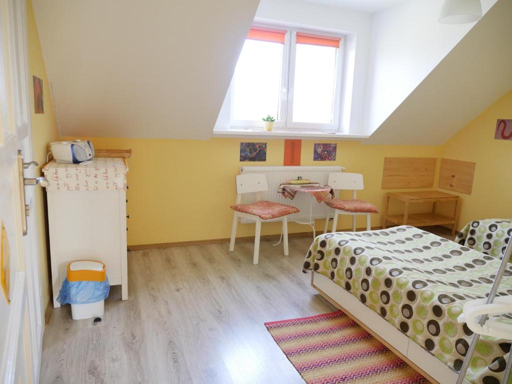 a bedroom with two beds and a table and a window at pl.Outback in Białowieża