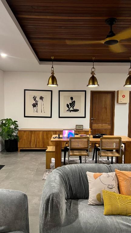 a living room with a couch and a table with a laptop at Lorn Villa in Nusa Penida