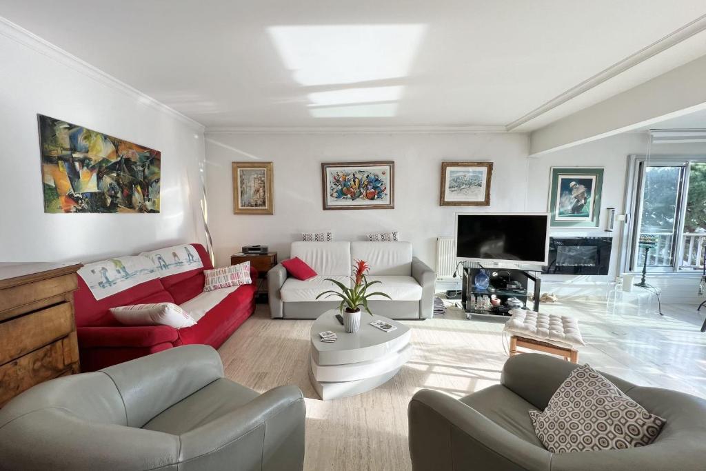 un salon avec deux canapés et une télévision dans l'établissement T3 with magnificent sea view, à Antibes