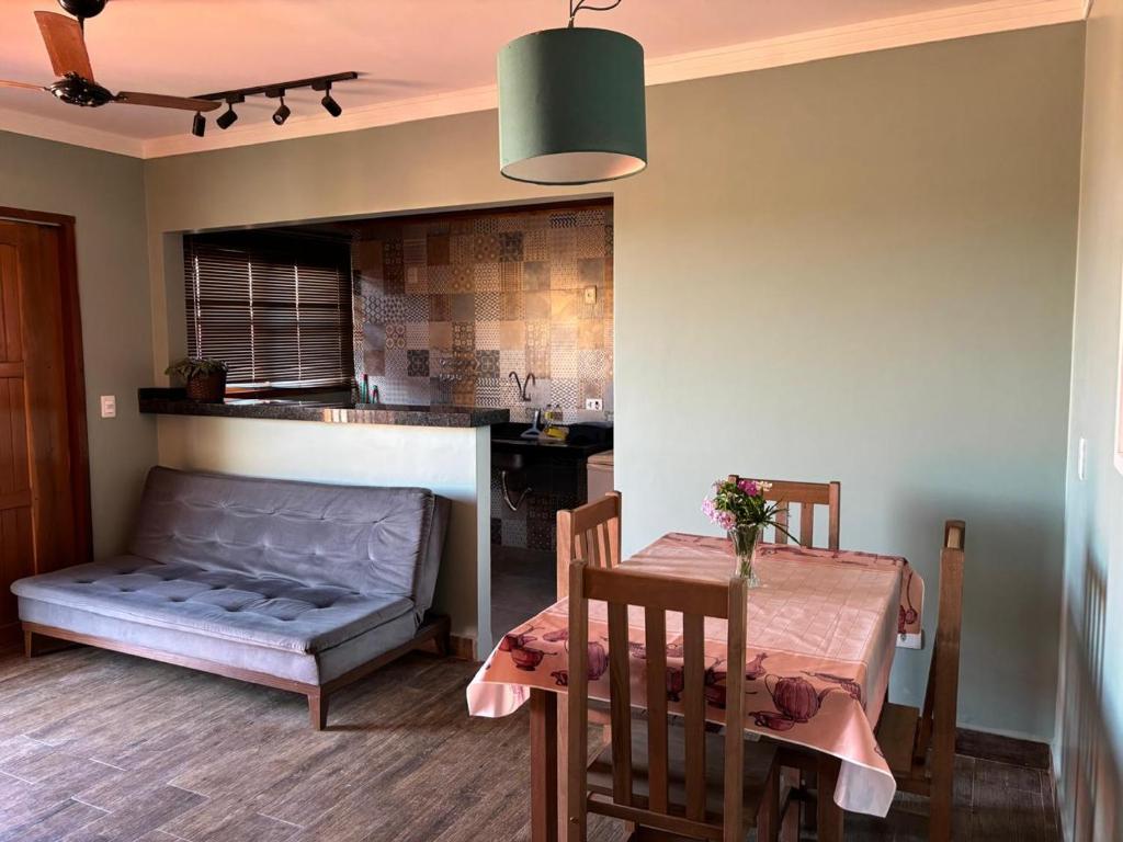 a dining room with a table and a couch in a kitchen at Flat Bonito Jarinu 02 Centro in Bonito