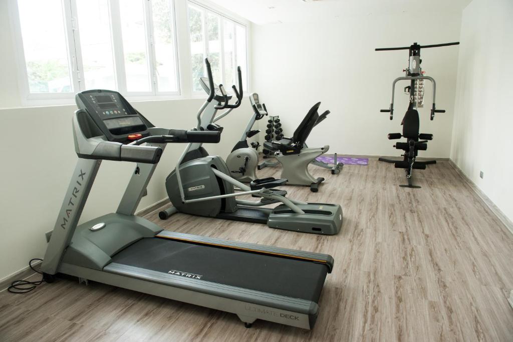 A bright gym centred on a treadmill, with additional cardio and strength equipment behind it.