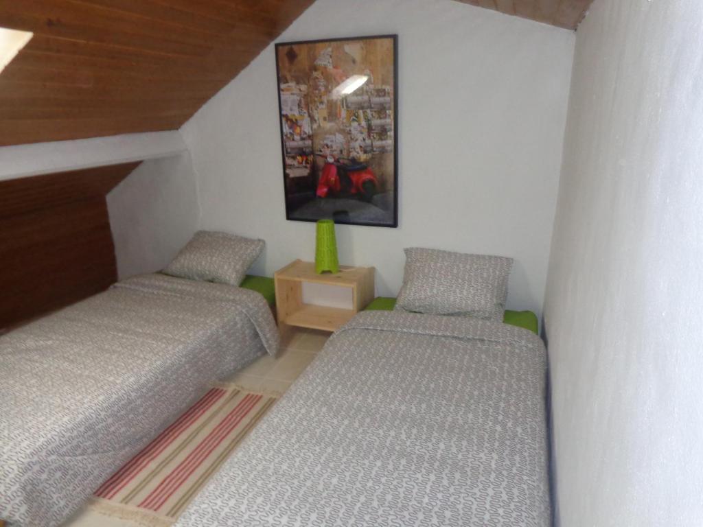 Cette chambre comprend 2 lits et une photo murale. dans l'établissement Casa da Turquinia, à Palmela