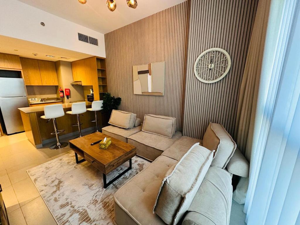 een woonkamer met een bank en een tafel bij 1BR Luxury Apartment - Woodyland in Sharjah Intl