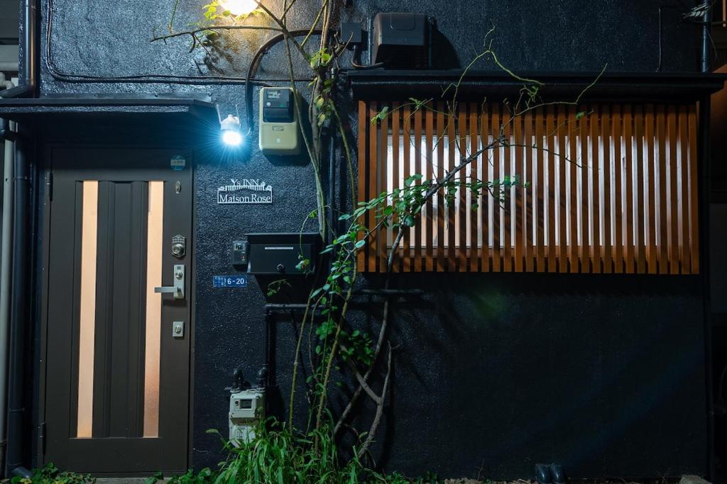 Y's INN MaisonRose 106T في طوكيو: مبنى بباب ومصنع بجانبه