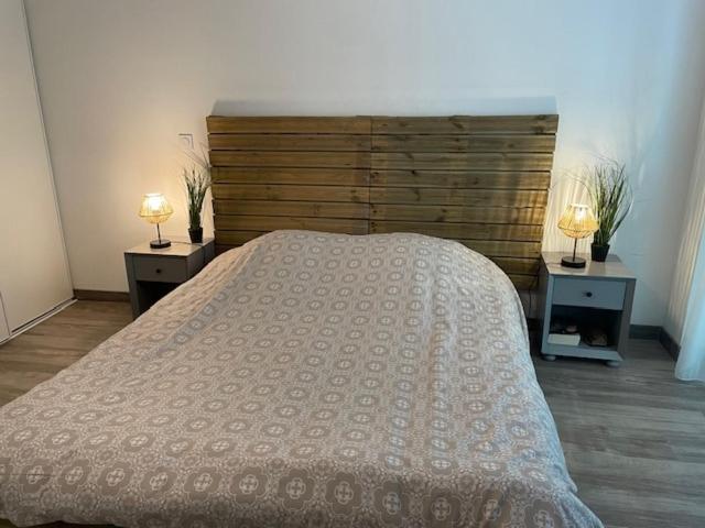 une chambre avec un grand lit et deux tables de nuit dans l'établissement Elegant studio with pool in Aix-en-Provence, à Éguilles