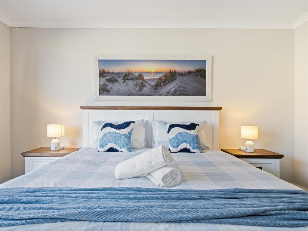 a bedroom with a large bed with blue and white pillows at Busselton Broadwater Holiday Home in Busselton