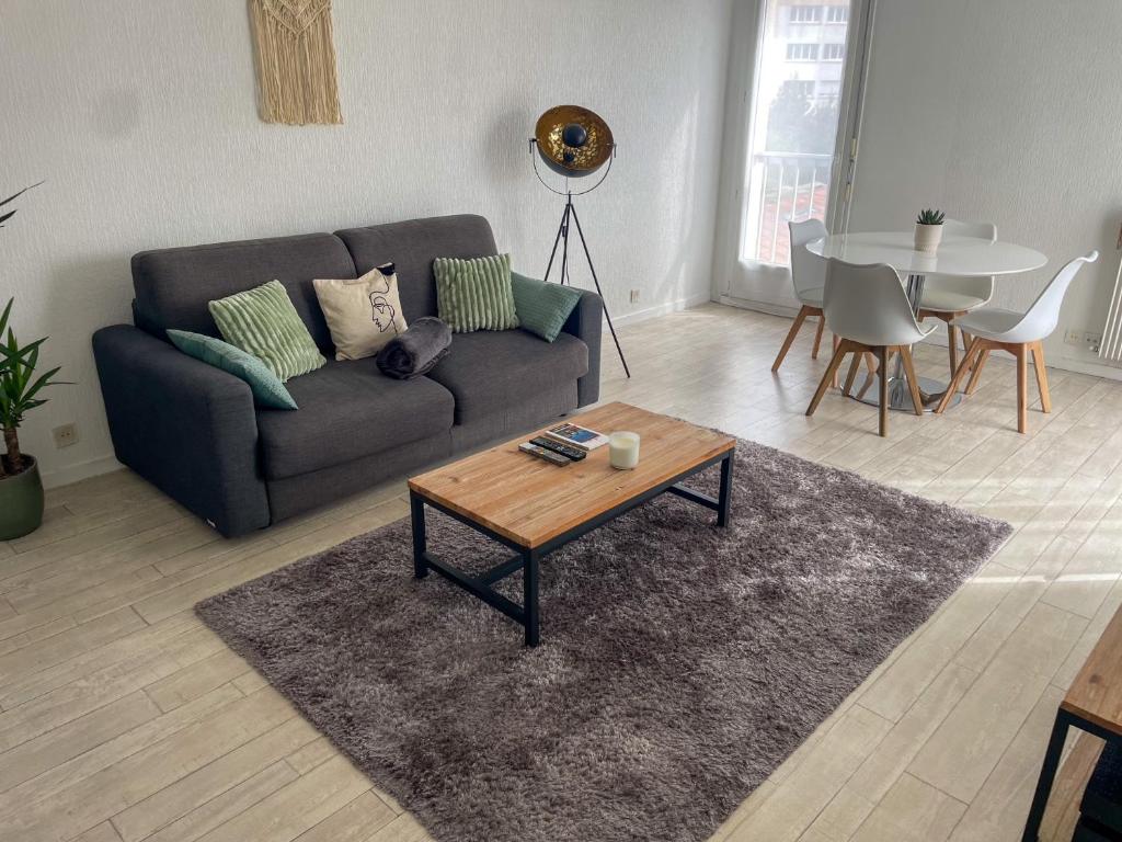 un salon avec un canapé et une table dans l'établissement T2 paisible et lumineux proche tram B, à Talence