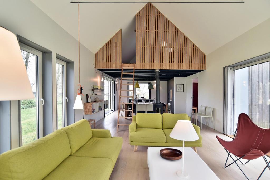 un salon avec un canapé vert et des chaises dans l'établissement Belle Ville - Maison lumineuse, cadre verdoyant, à Saint-Briac-sur-Mer