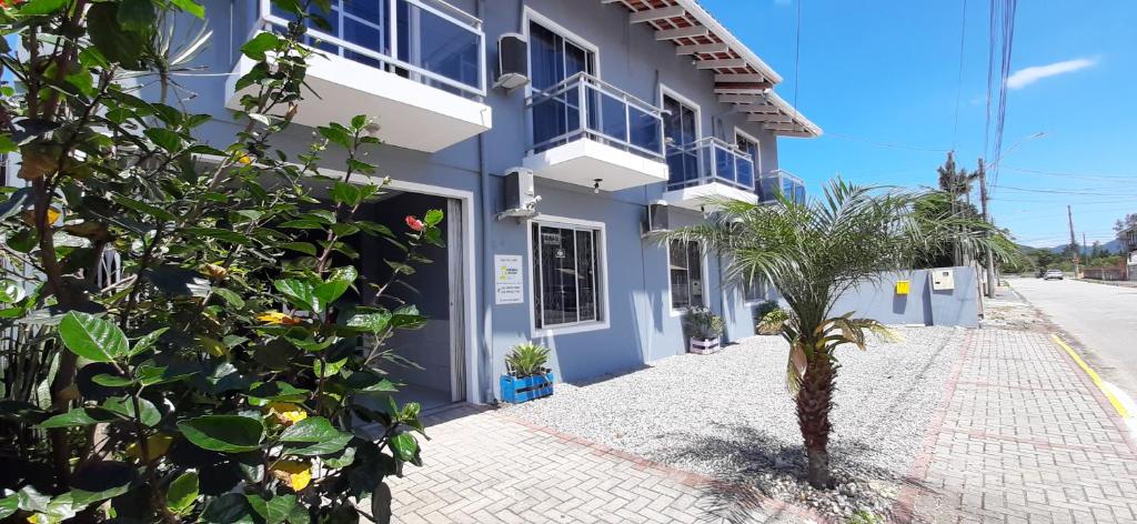 um prédio azul com uma palmeira na frente em Pousada Splash em Florianópolis