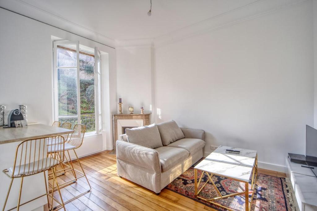 un salon avec un canapé et une table dans l'établissement Elegance Versaillaise, à Versailles