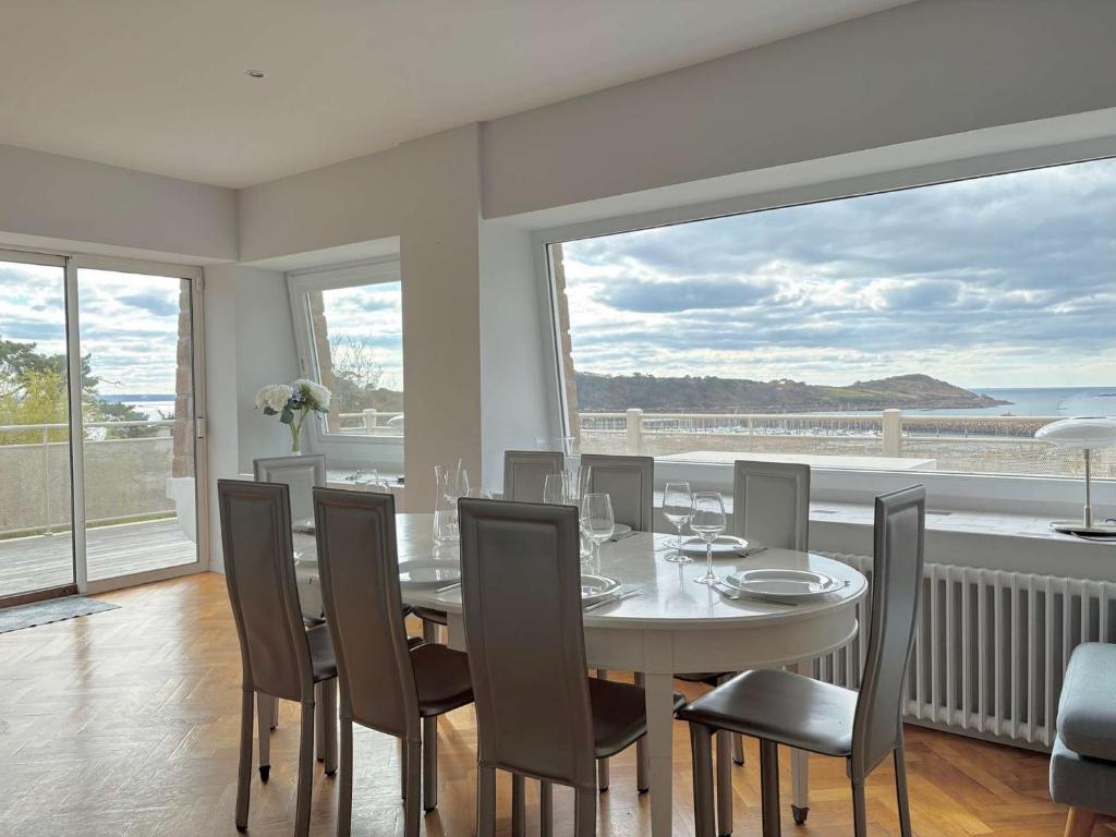 une salle à manger avec une table et des chaises et une grande fenêtre dans l'établissement Superbe maison avec jardin, proche plage, chiens admis - FR-1-542-25, à Trébeurden
