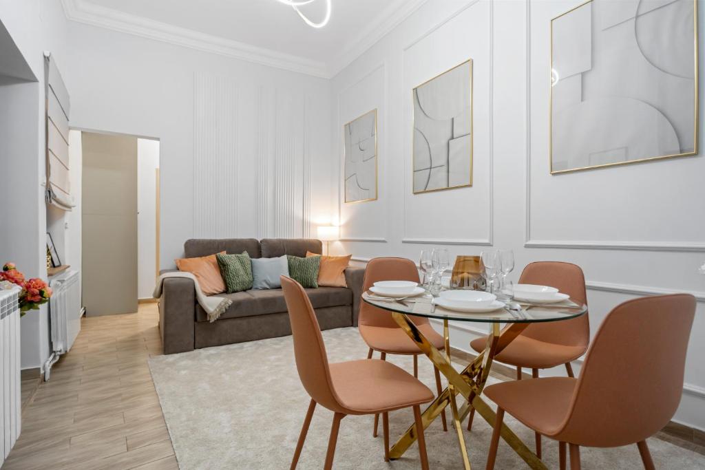 a living room with a table and chairs and a couch at Central Luxury Apartments with Private Garden & Parking in Bucharest