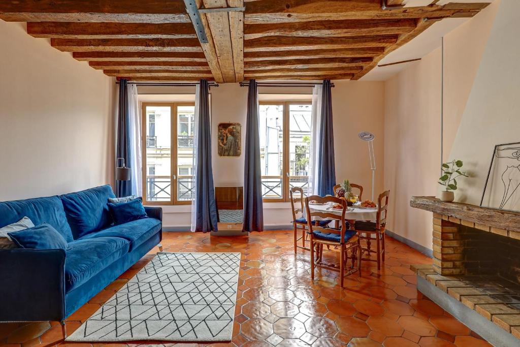 un salon avec un canapé bleu et une table dans l'établissement BnBNova - 1BR - The Heart of Le Marais, à Paris