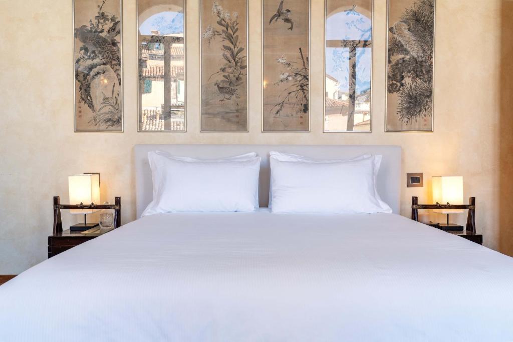 a bedroom with a large white bed with two pillows at Palazzo Remer - luxury apartments - by Bricola Apartments in Venice
