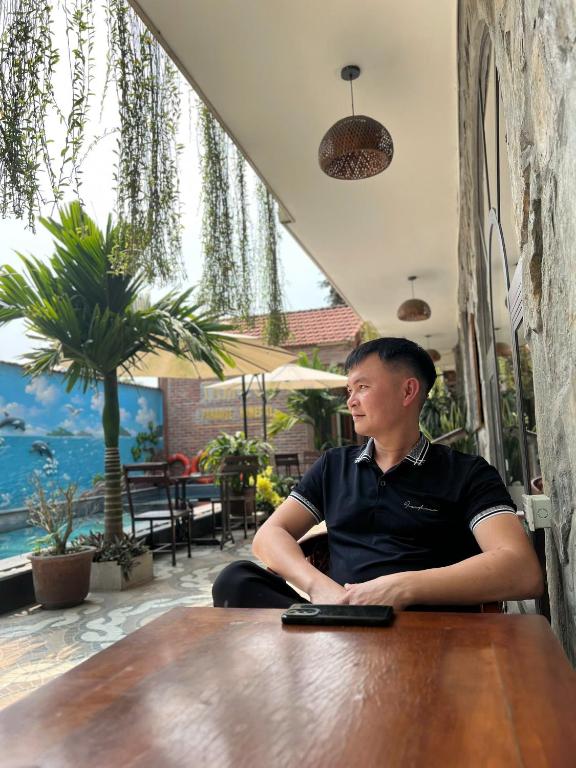 a man sitting at a table in a restaurant at Tam Coc Paradise Homestay in Ninh Binh