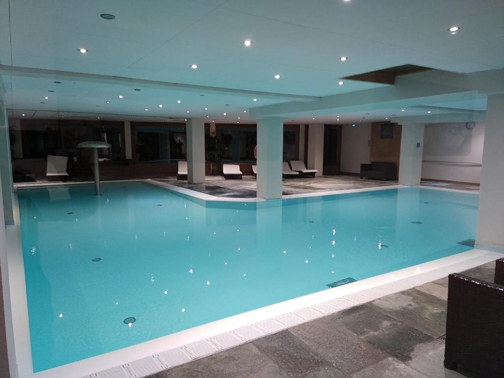 a large blue swimming pool in a building at Duplex résidence spa Mont-Blanc in Vallorcine