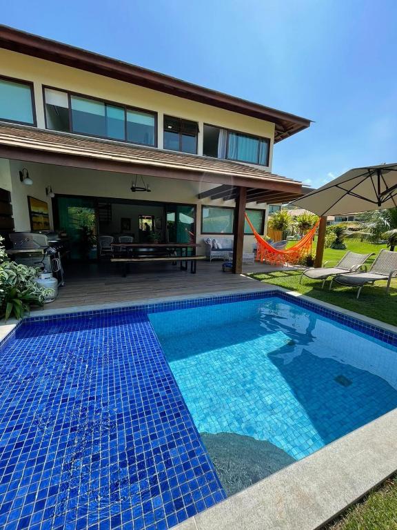 a swimming pool in front of a house at House 16 - Reserva dos Carneiros in Tamandaré