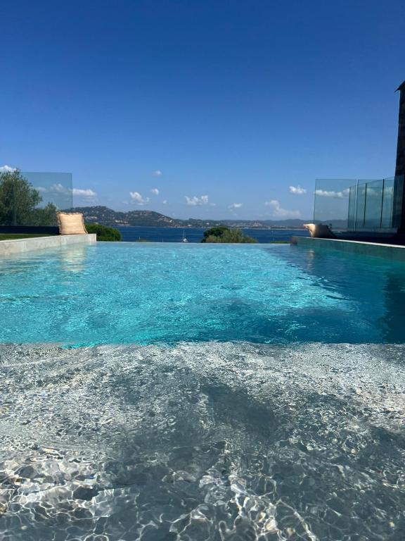 - une piscine d'eau bleue au sol dans l'établissement Villa PERLE DE GIENS, à Hyères