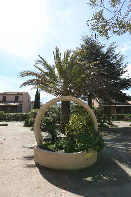 une sculpture d'un palmier dans un parking dans l'établissement St Cyprien moderne maison T2 mezzanine proche plage, à Saint-Cyprien