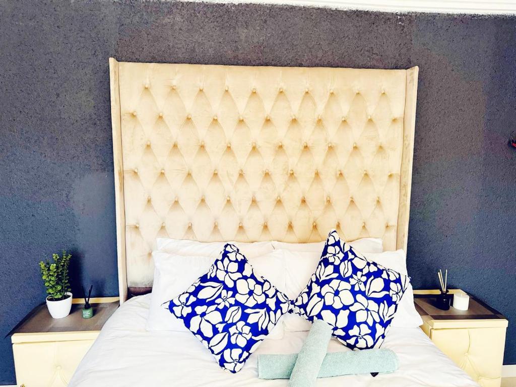 a bed with blue and white pillows on it at Bakwena Lodge in Jane Furse