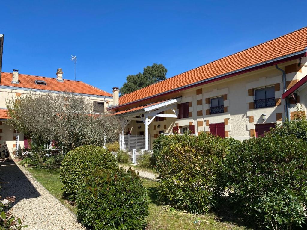 un bâtiment avec des buissons devant lui dans l'établissement St THOMAS, à La Teste-de-Buch
