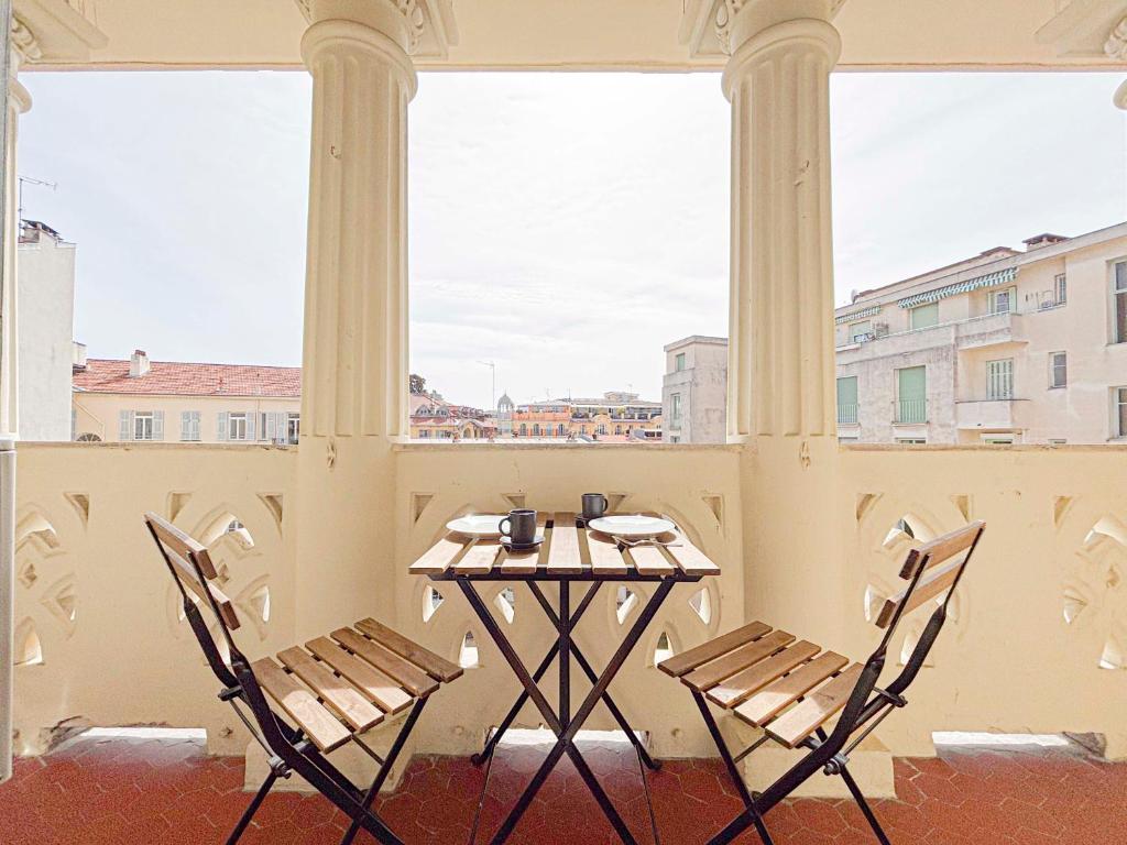 une table et des chaises sur un balcon avec vue dans l'établissement Escapade en centre ville de Nice - Wifi, AC, 2pers, à Nice