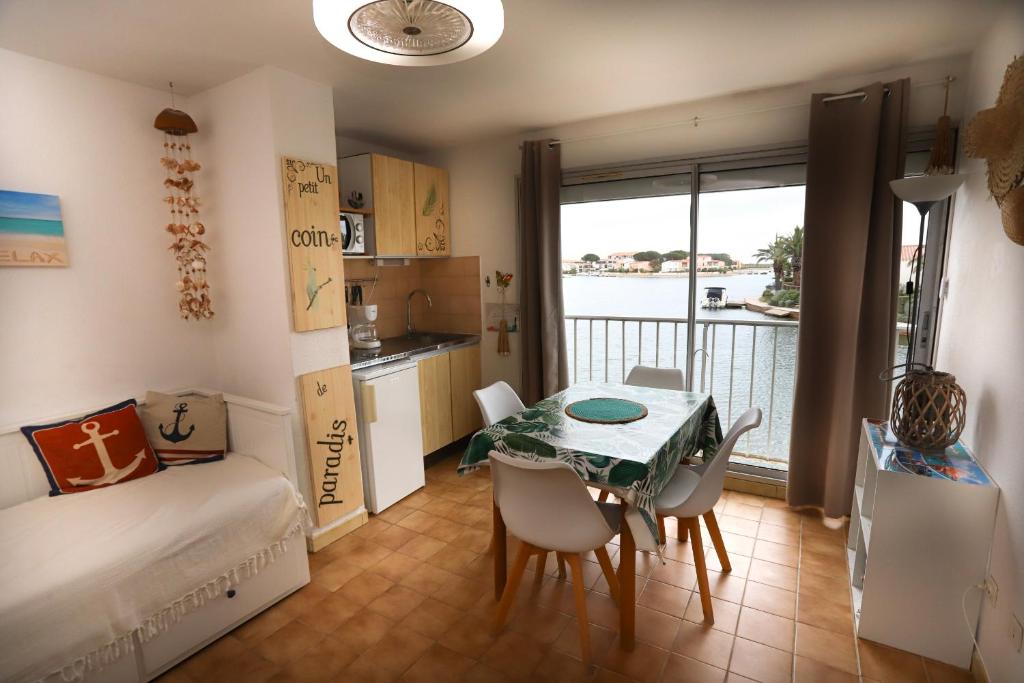 Cet appartement comprend une chambre avec une table et un lit ainsi qu'une cuisine. dans l'établissement St Cyprien charmant Studio proche de la marina, à Saint-Cyprien