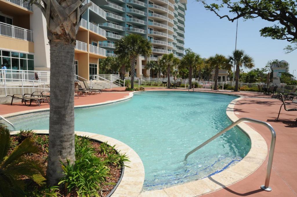 una grande piscina con una palma di fronte a un edificio di Legacy Tower Two 602 a Gulfport