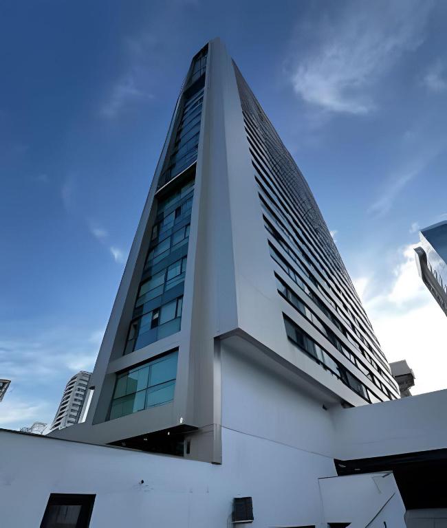 a tall white building with a blue sky in the background at Flat Luxo Boa Viagem Perto da Praia e Shopping Recife in Recife