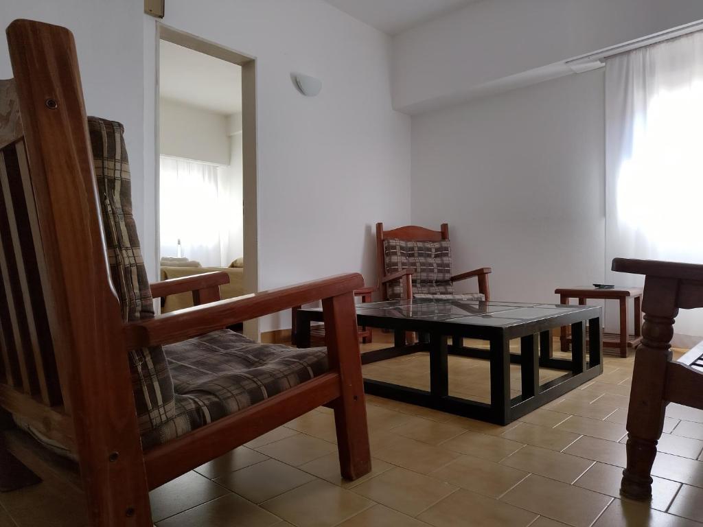 a living room with a table and a chair at Departamentos Arenales in Viedma