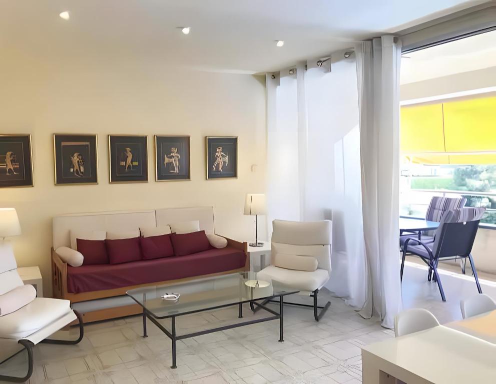 a living room with a red couch and chairs at Apartamento Francás in Comarruga