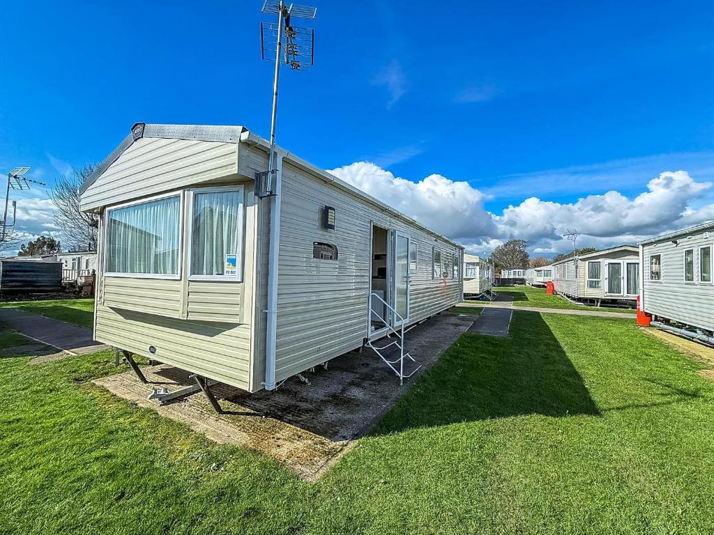 a tiny house is parked in a yard at Lovley 8 Berth Caravan At Dovercourt Park, Essex Ref 44202B in Great Oakley