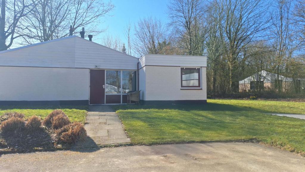 ein kleines weißes Haus mit einem Fenster im Hof in der Unterkunft Bungalowpark Simpelveld - Schakel 24 in Simpelveld