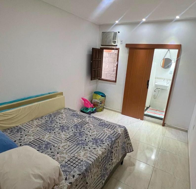 een slaapkamer met een bed en een magnetron. bij Praia Grande House in Fundão