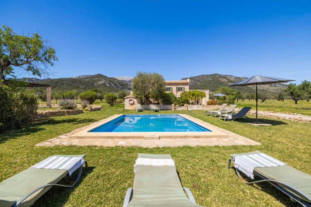 a pool with two lounge chairs and an umbrella at Casa de los Almendros in Selva