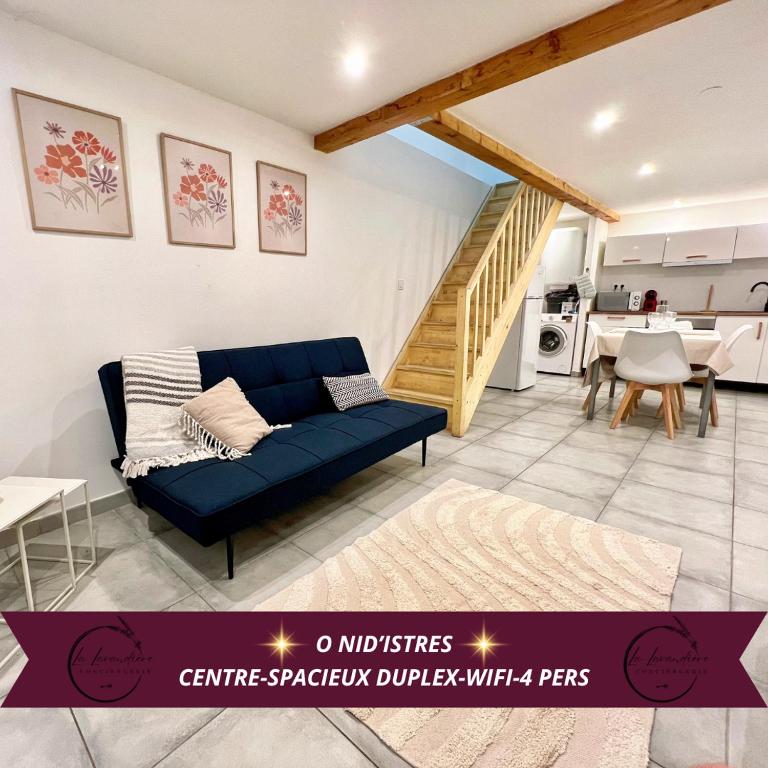 un salon avec un canapé bleu et une cuisine dans l'établissement O Nid'Istres - Centre Historique, Spacieux Studio Duplex, Wifi, 4 personnes, à Istres