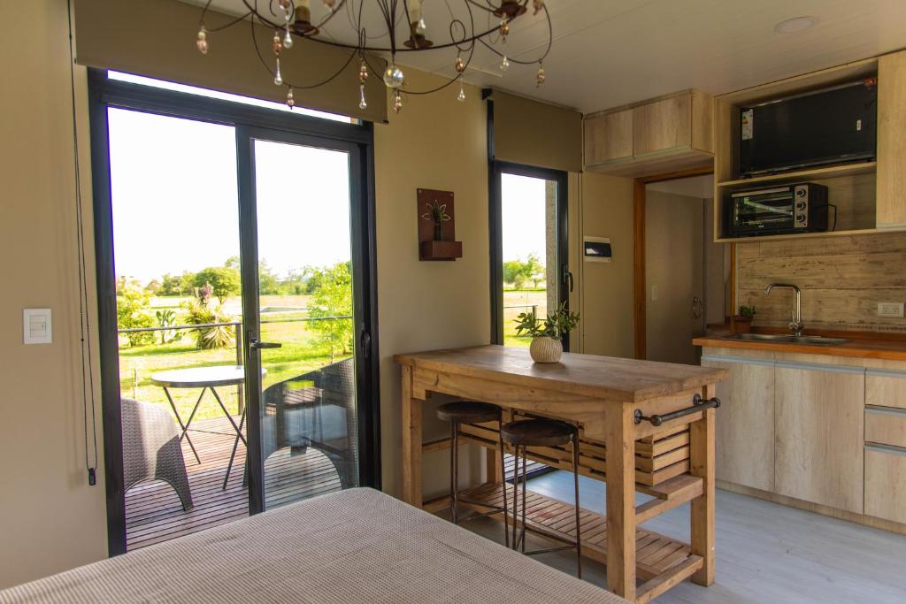cocina con mesa y vistas a un patio en La Quinta, Cabañas de campo, en Villa Nueva