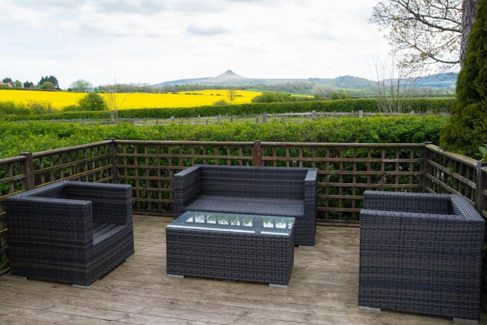 zwei Korbstühle und eine Bank auf einer Terrasse in der Unterkunft The Treebridge Hotel in Nunthorpe