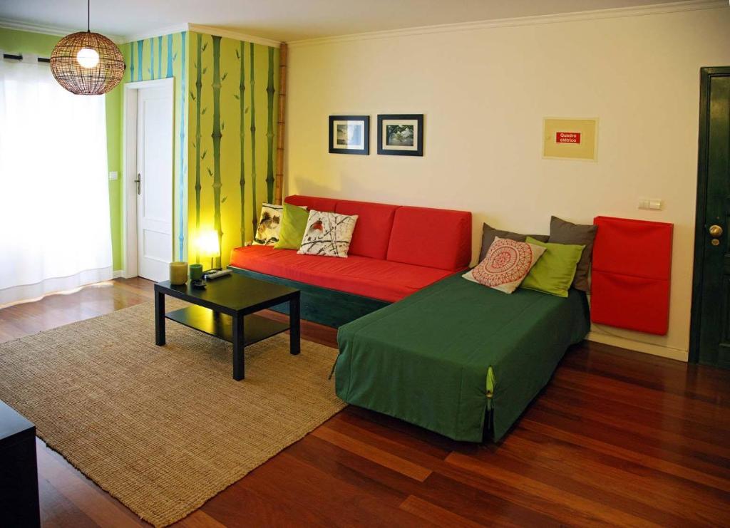 uma sala de estar com um sofá vermelho e uma mesa em Casa do Cavacas em Funchal