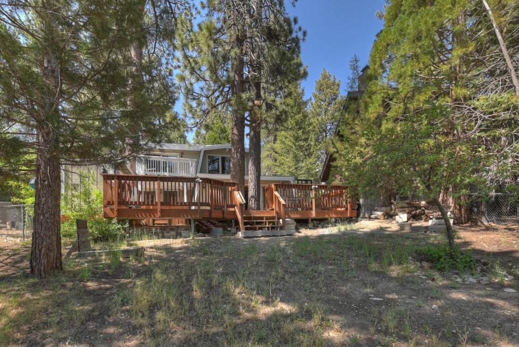 ein Baumhaus mit einer Terrasse im Wald in der Unterkunft Peaceful Sunshine Chalet with Hot Tub in Big Bear Lake
