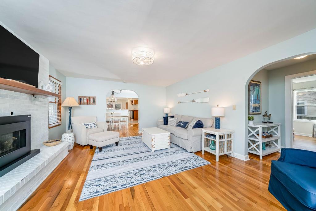 a living room with white furniture and a fireplace at 5 Bedroom with Fire Pit, Patio & Large Yard in South Haven