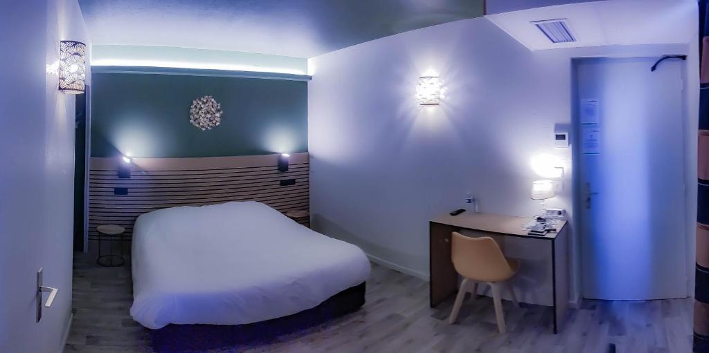 Logis Les Charmilles Chalon-sur-Saône Sud في Lux: غرفة بسرير ومكتب وسرير وكرسي