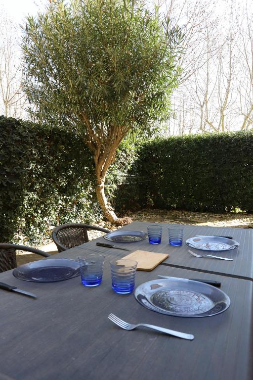 une table avec des assiettes et des verres bleus dans l'établissement St Cyprien appartement proche plage, à Saint-Cyprien