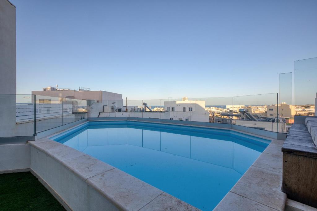 a swimming pool on the roof of a building at Beautiful Penthouse with pool and terrace in Is-Swieqi
