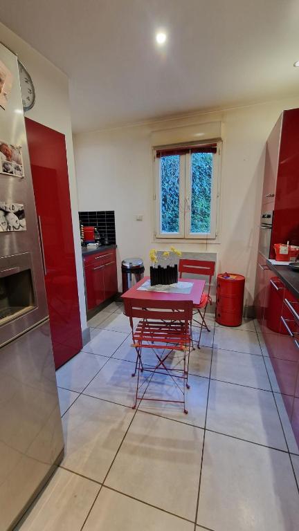 une cuisine avec une table rouge et des placards rouges dans l'établissement Montagne CORSE, à Pietroso