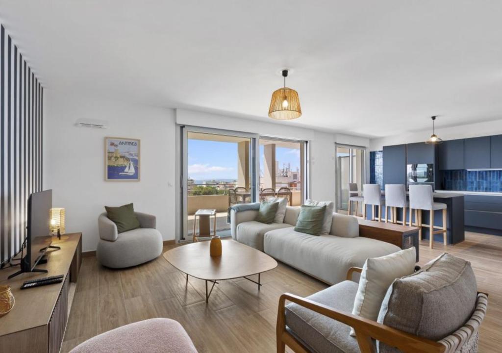 un salon avec un canapé et une table dans l'établissement Duplex Elegante Vista Panorâmica 360 Juan-les-Pins, à Antibes