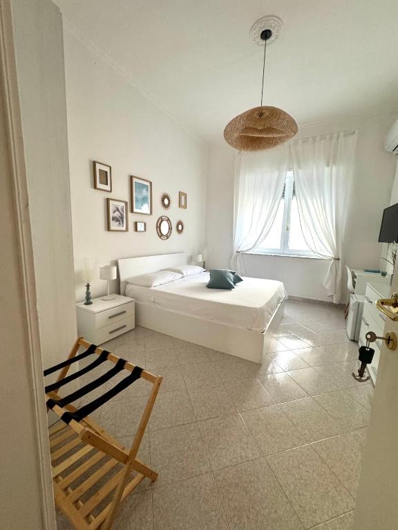 una camera bianca con un letto e una finestra di A Due Passi dal Mare B&B a Scalea