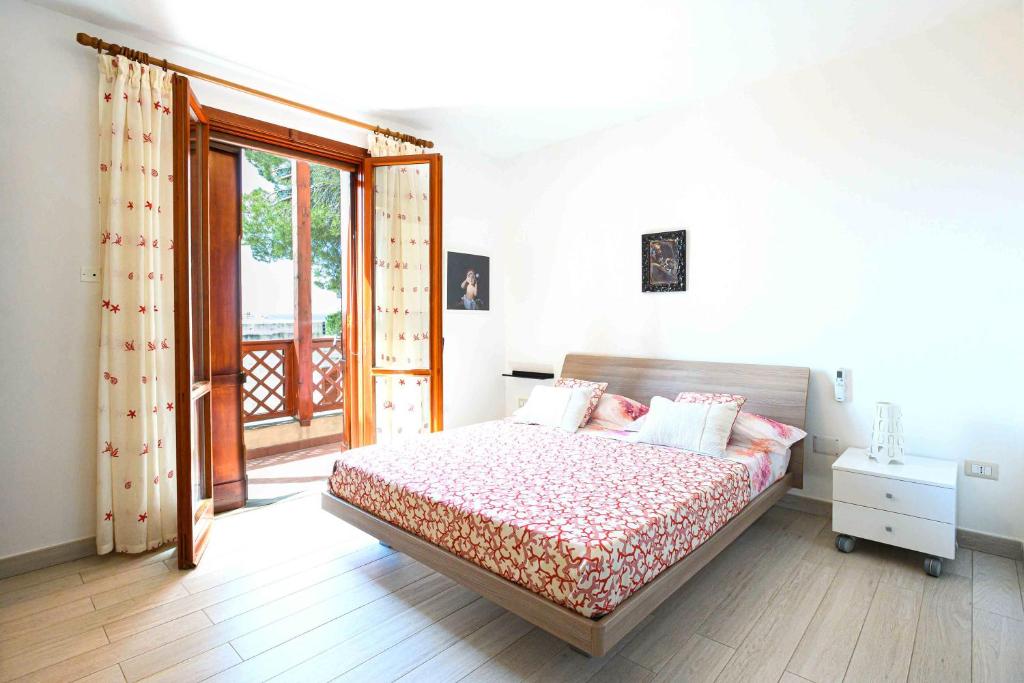 a bedroom with a bed and a door to a balcony at Villa con piscina in parco privato in Agnone