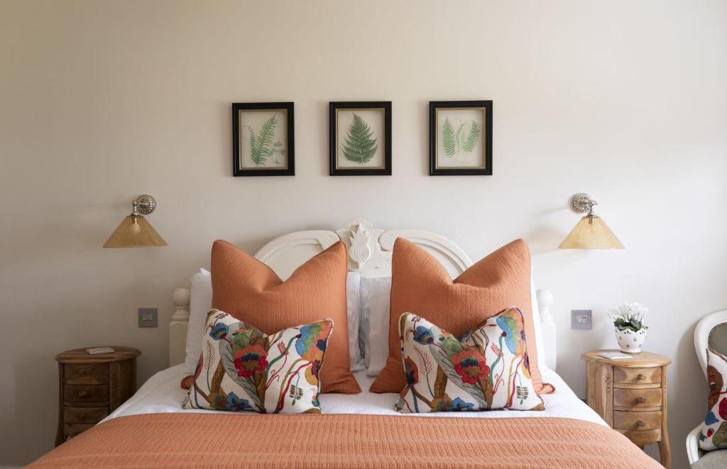 - une chambre avec un lit doté de draps et d'oreillers orange dans l'établissement Greenhead Cottage, à Kelso