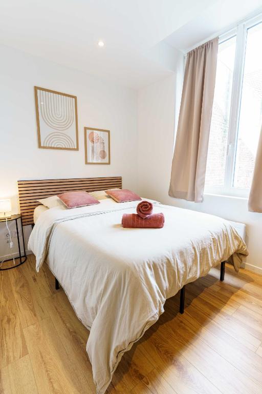 un grand lit blanc dans une chambre avec une fenêtre dans l'établissement Studio Relax 2pers wifi, à Saint-Quentin